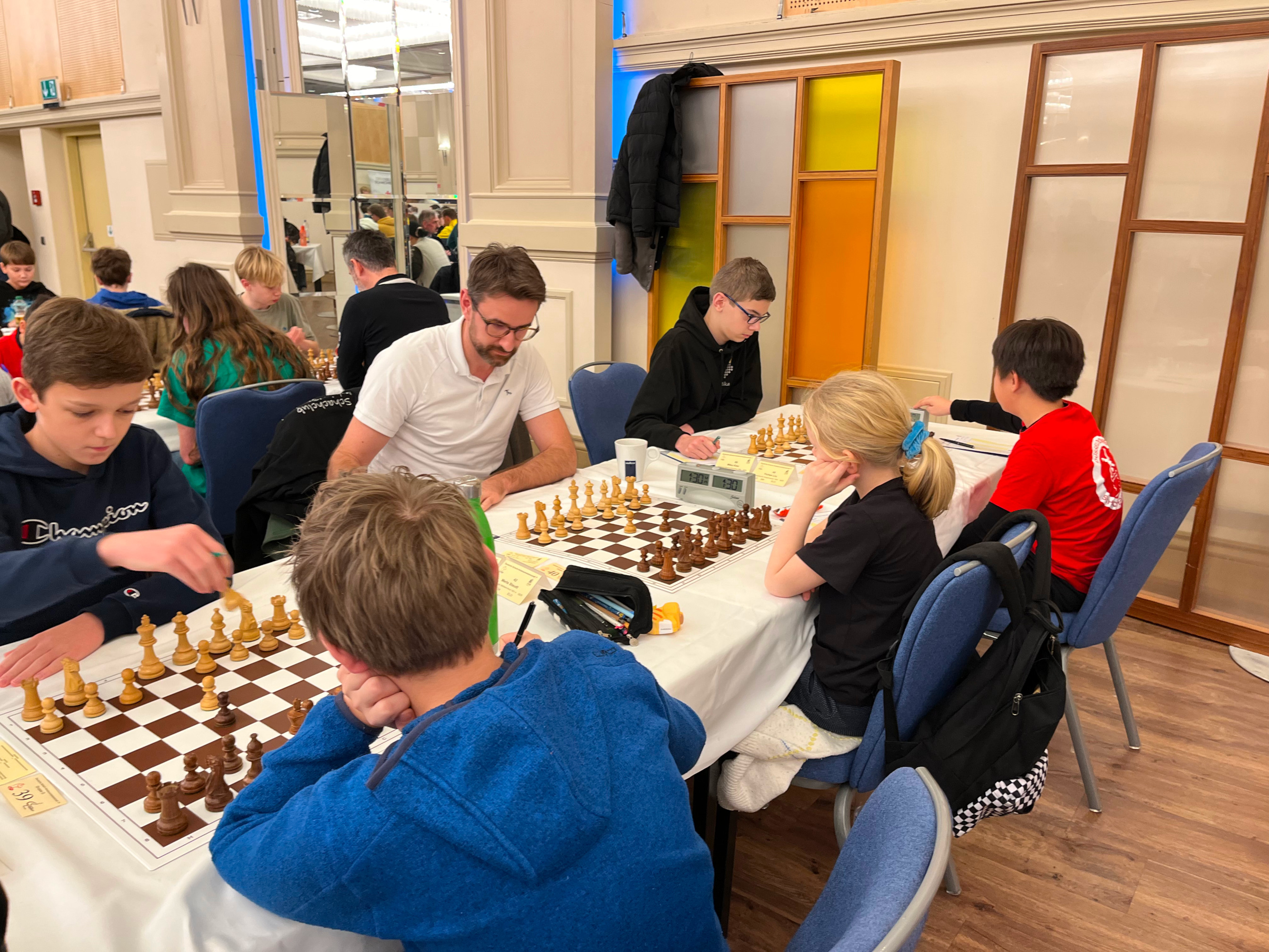 Ein Bild von drei Monheimer Schach-Spielern an ihren Brettern