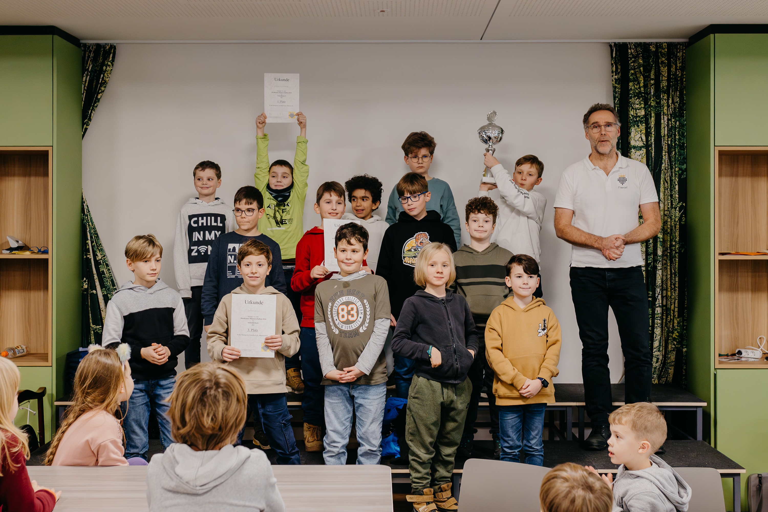Die Schüler aus den drei bestplatzierten Mannschaften halten stolz ihre Urkunden und den Pokal in die Luft.